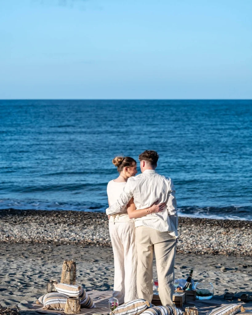 Couple enjoying a romantic beach picnic setup in Crete by the sea