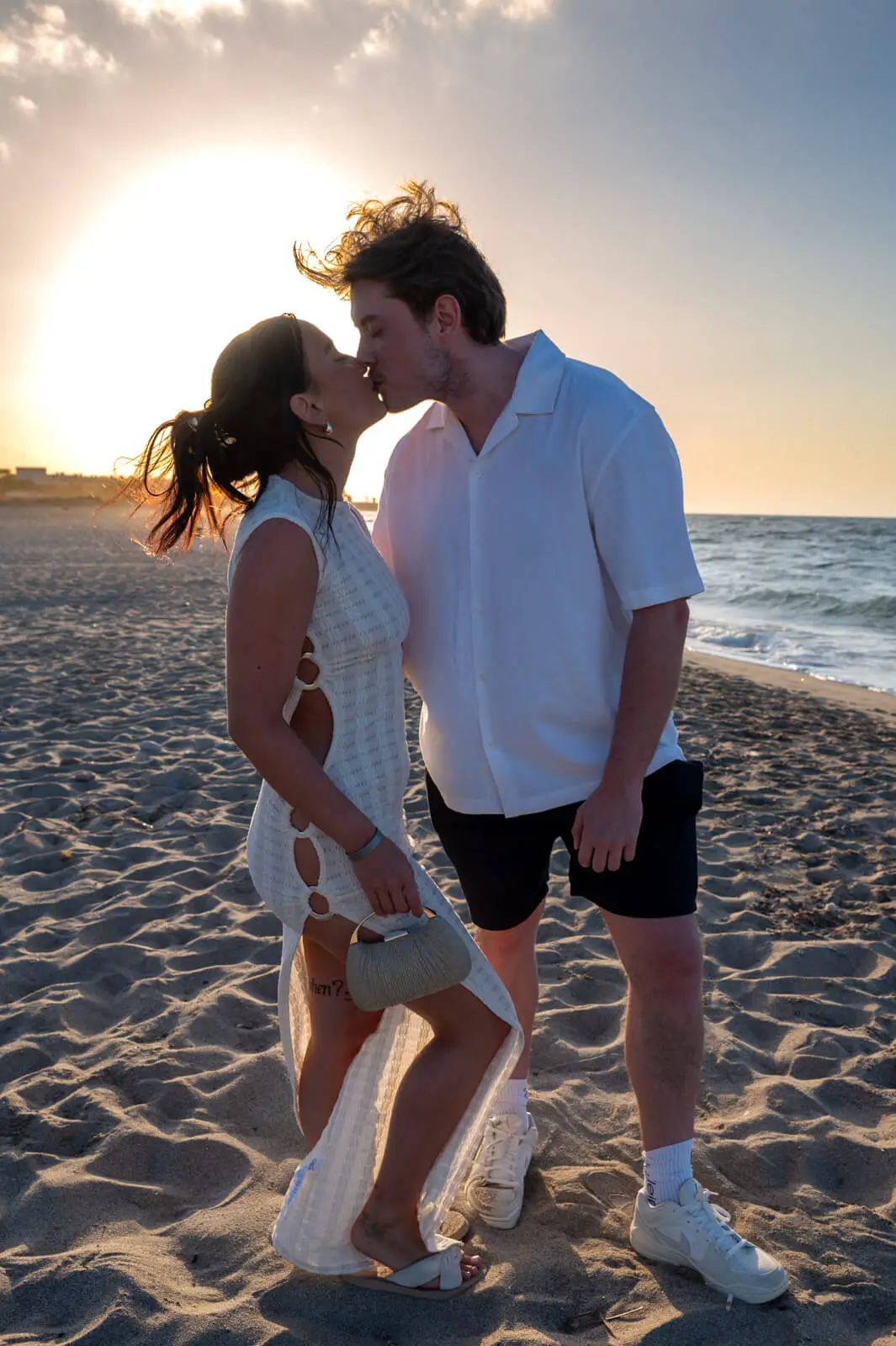 Couple kissing on a beach in Crete during golden hour sunset proposal