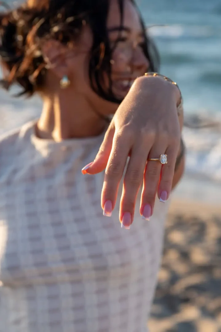 Close-up of a groom showing a proposal ring during a beach engagement in Aposelemis, Crete