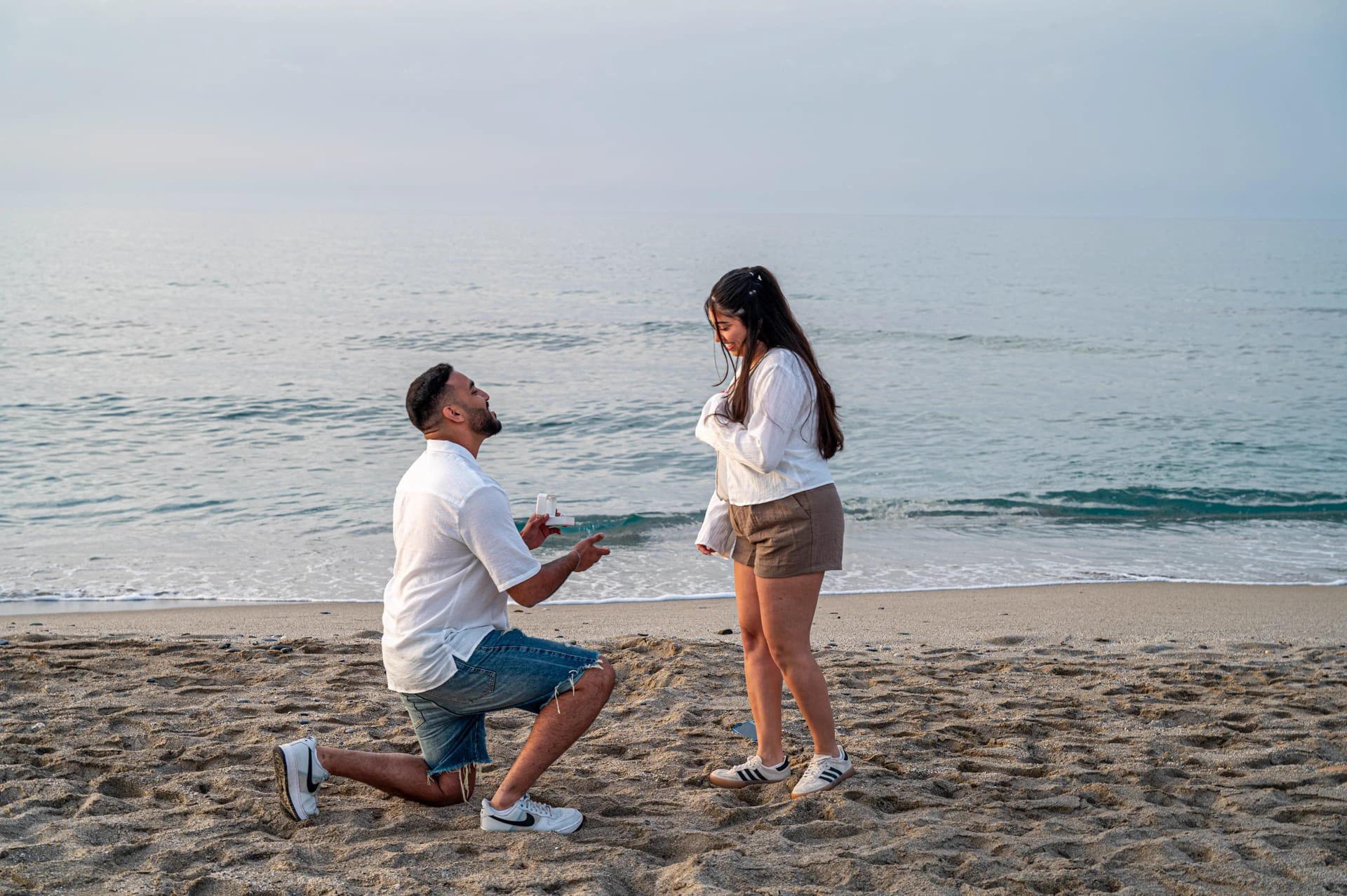 A romantic beach proposal during sunset at Aposelemis Beach in Crete with a couple sharing an intimate moment by the sea