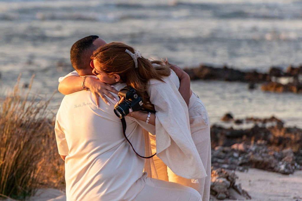 Emotional embrace after a surprise proposal at Falassarna Beach in Crete.
