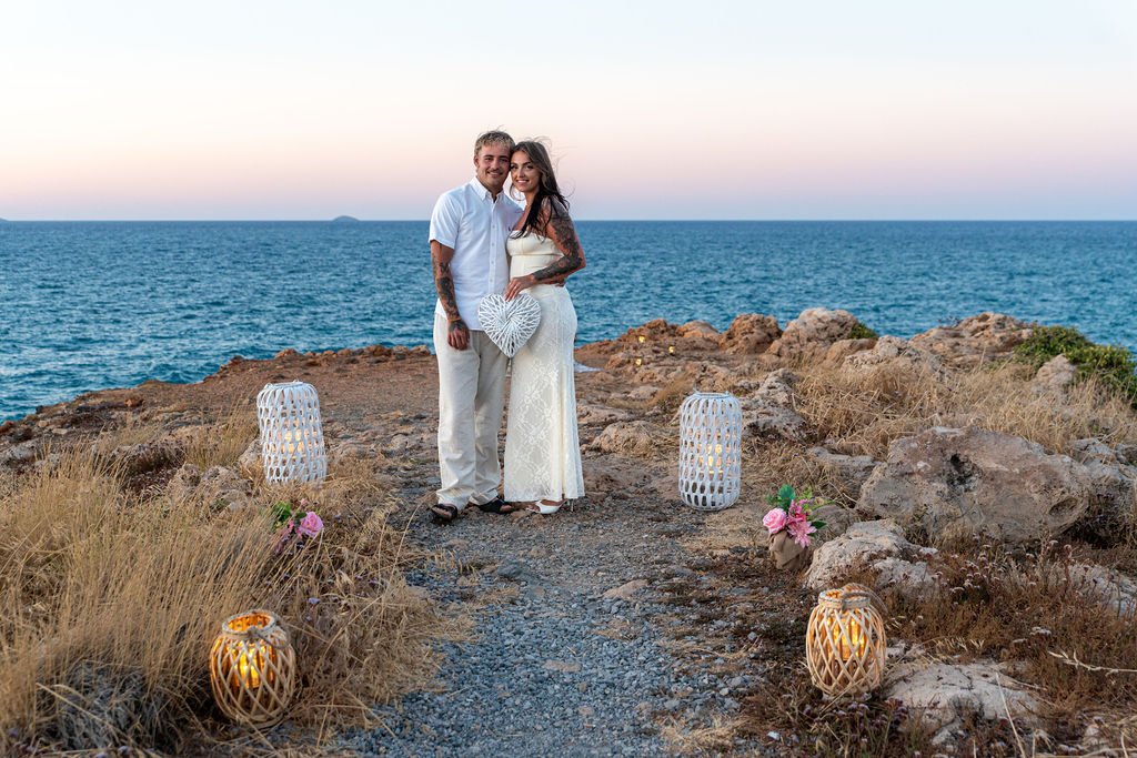 Couple beside a romantic proposal setup on the coast of Heraklion, Crete.